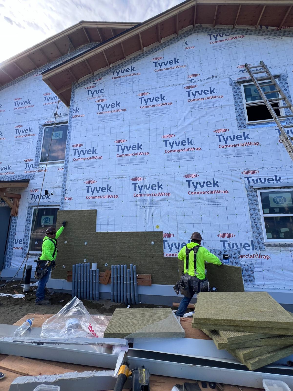 Crew installing Rockwool ComfortBoard exterior insulation over the WRB